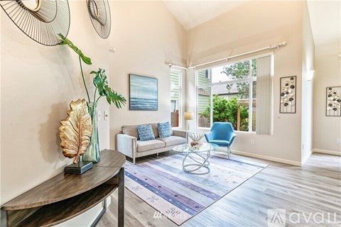 A living room with a white sofa and a blue chair.