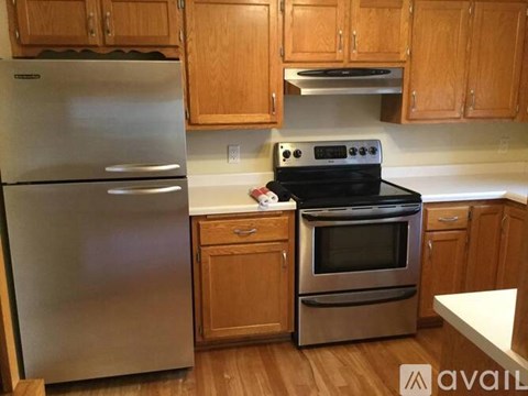 A kitchen with a stainless steel refrigerator, oven, and cabinets.
