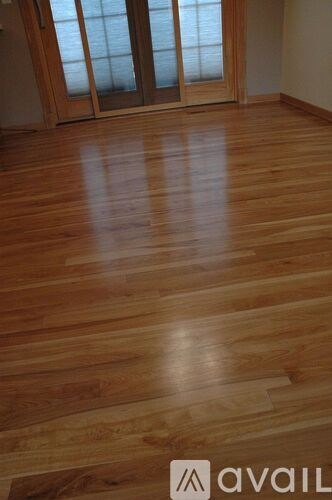 A room with wooden flooring and a sliding glass door.