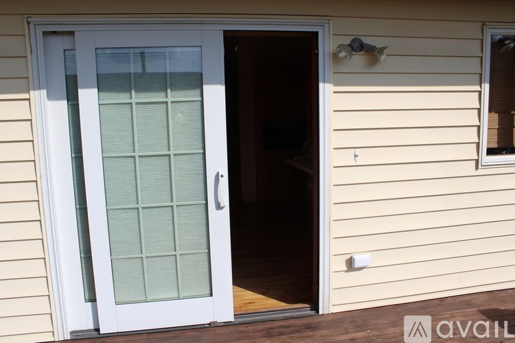 A white door with a glass panel is open to a dark interior.