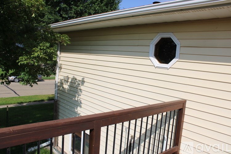 A house with a round window and a wooden balcony.