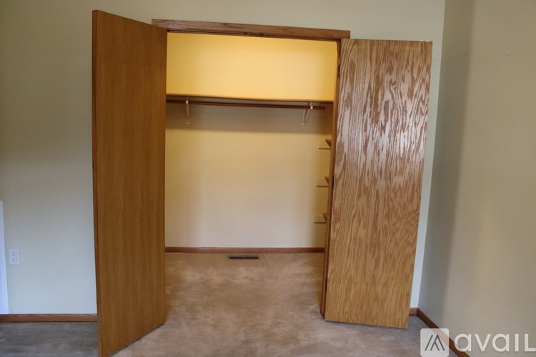 A room with a wooden door and a light on the ceiling.