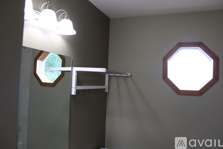 A bathroom with a towel rack and mirrors.
