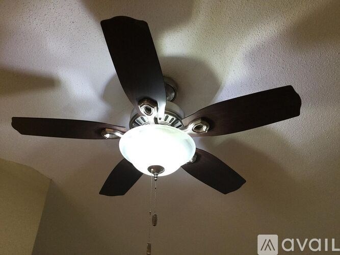 A ceiling fan with a light fixture is hanging from the ceiling.