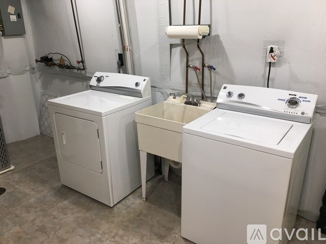 Two white washing machines in a laundry room.