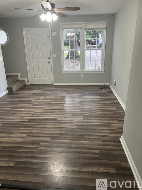 A room with wooden flooring and a ceiling fan.