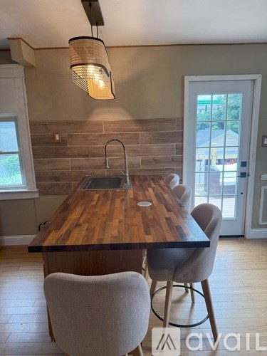 A kitchen with a wooden table and chairs.