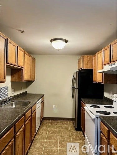 A kitchen with wooden cabinets and black appliances.