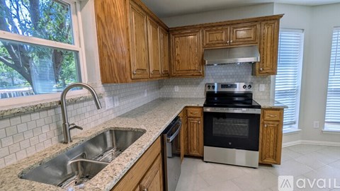A kitchen with wooden cabinets and a granite countertop.