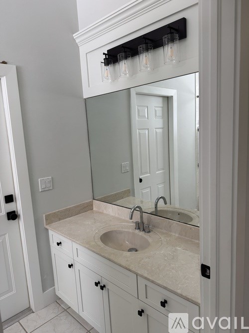 A bathroom with a sink and a mirror.