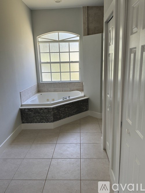 A bathroom with a large tub and a window.