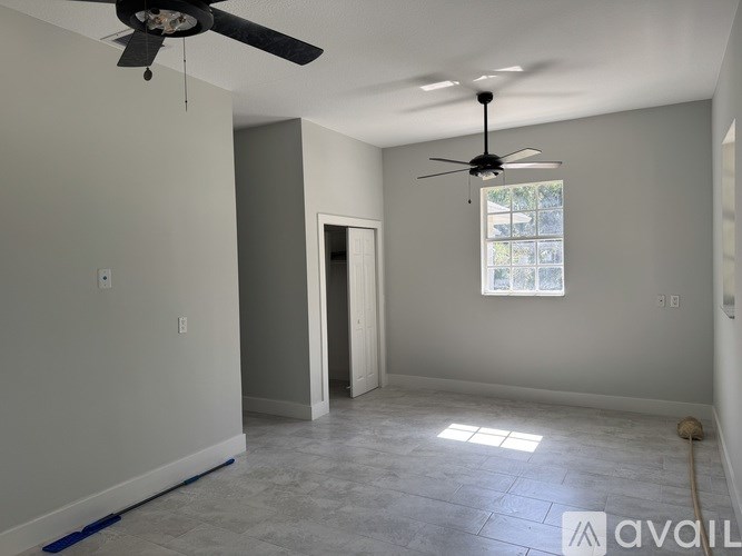 A room with a ceiling fan and a window.