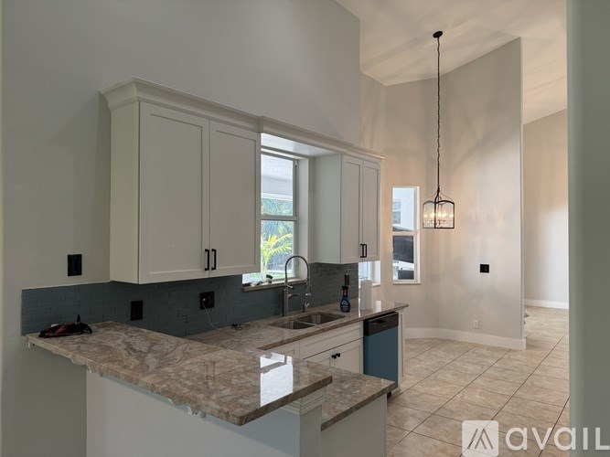 A kitchen with granite countertops and white cabinets.