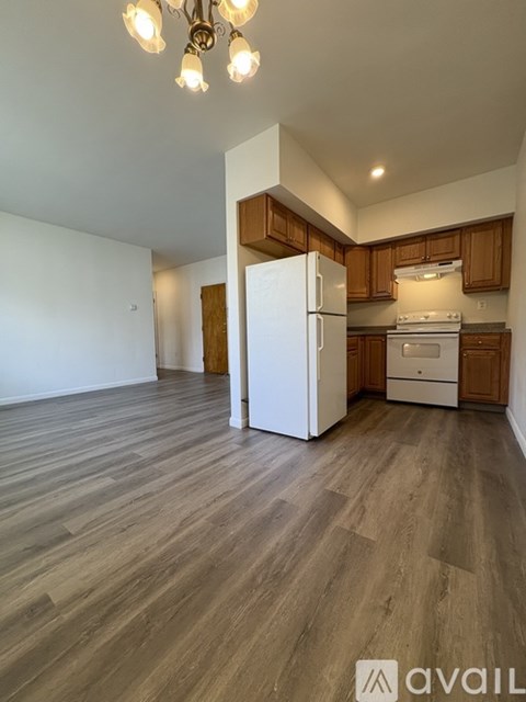 A kitchen with wooden cabinets and a white fridge.