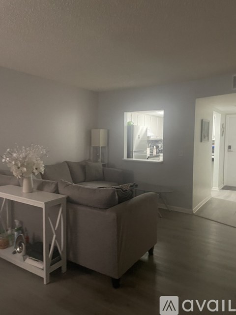 A living room with a grey couch and a white coffee table.