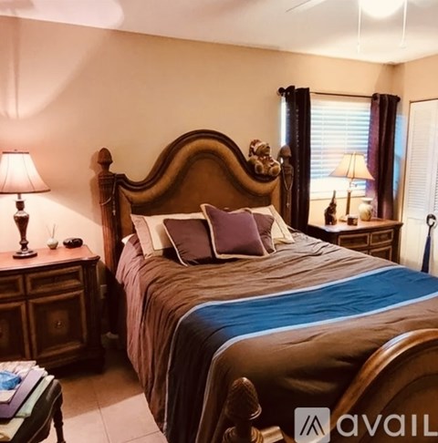 A bedroom with a large bed and a wooden headboard.