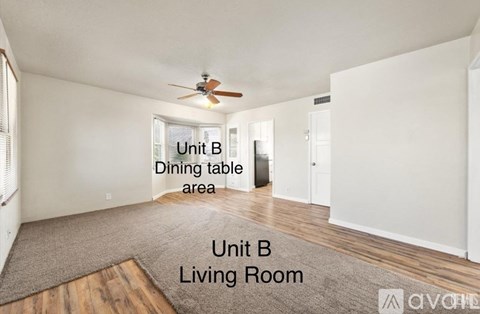 A living room with a dining table area and a ceiling fan.