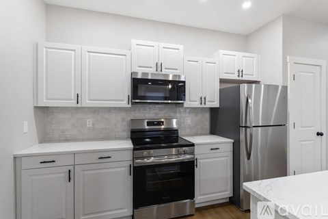 A kitchen with white cabinets and stainless steel appliances.
