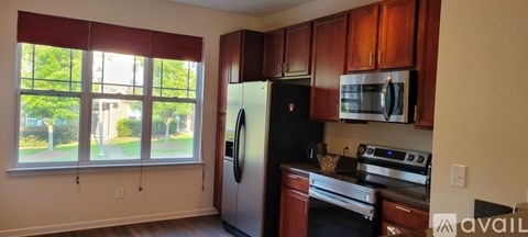 A kitchen with wooden cabinets and a black refrigerator.