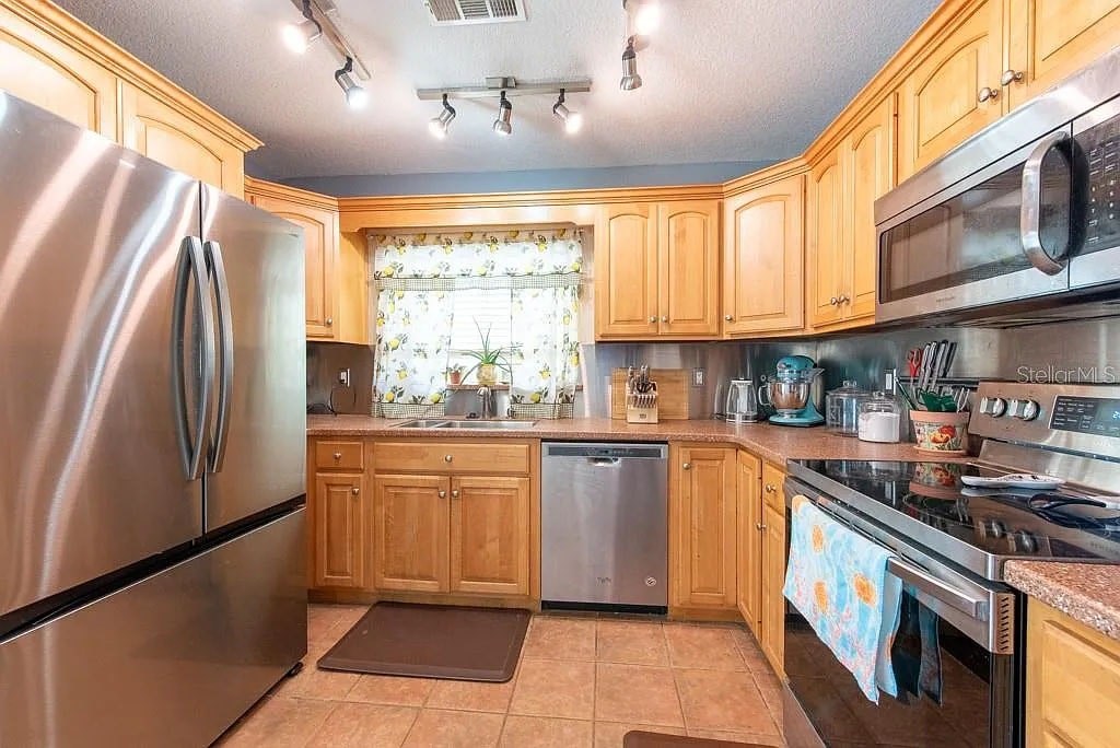 A kitchen with wooden cabinets and stainless steel appliances.