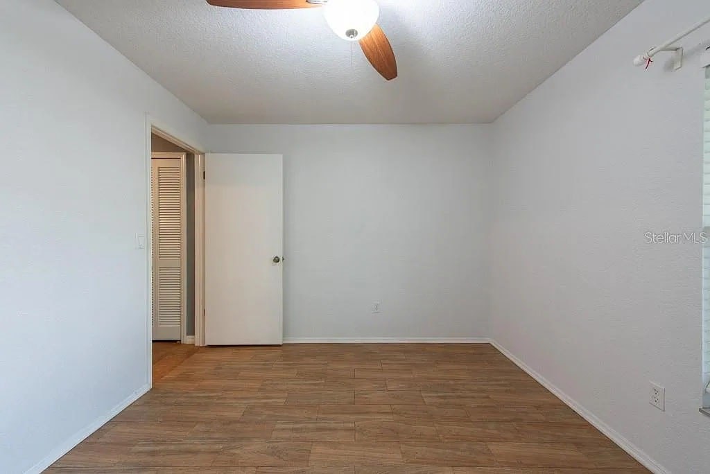 A room with a wooden floor and a ceiling fan.