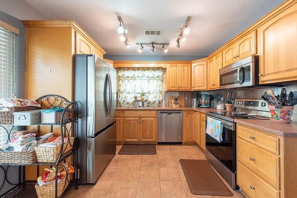 A kitchen with wooden cabinets and a refrigerator.