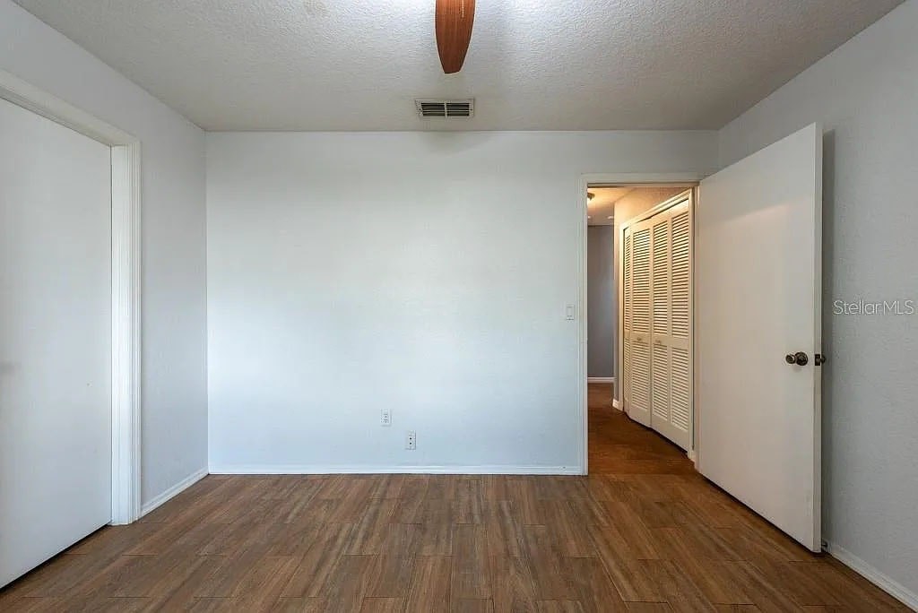 A room with wood flooring and white walls.