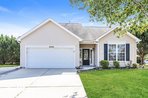 A house with a white garage door and a black window.