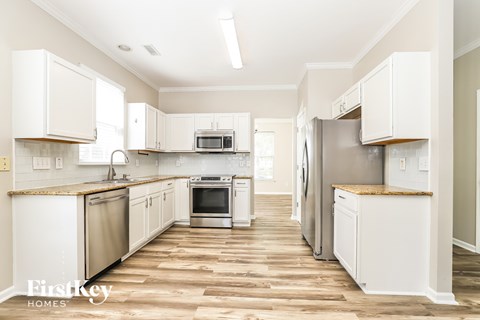 A kitchen with white cabinets and stainless steel appliances.