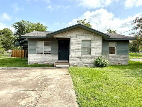 A house with a grey roof and a green lawn.