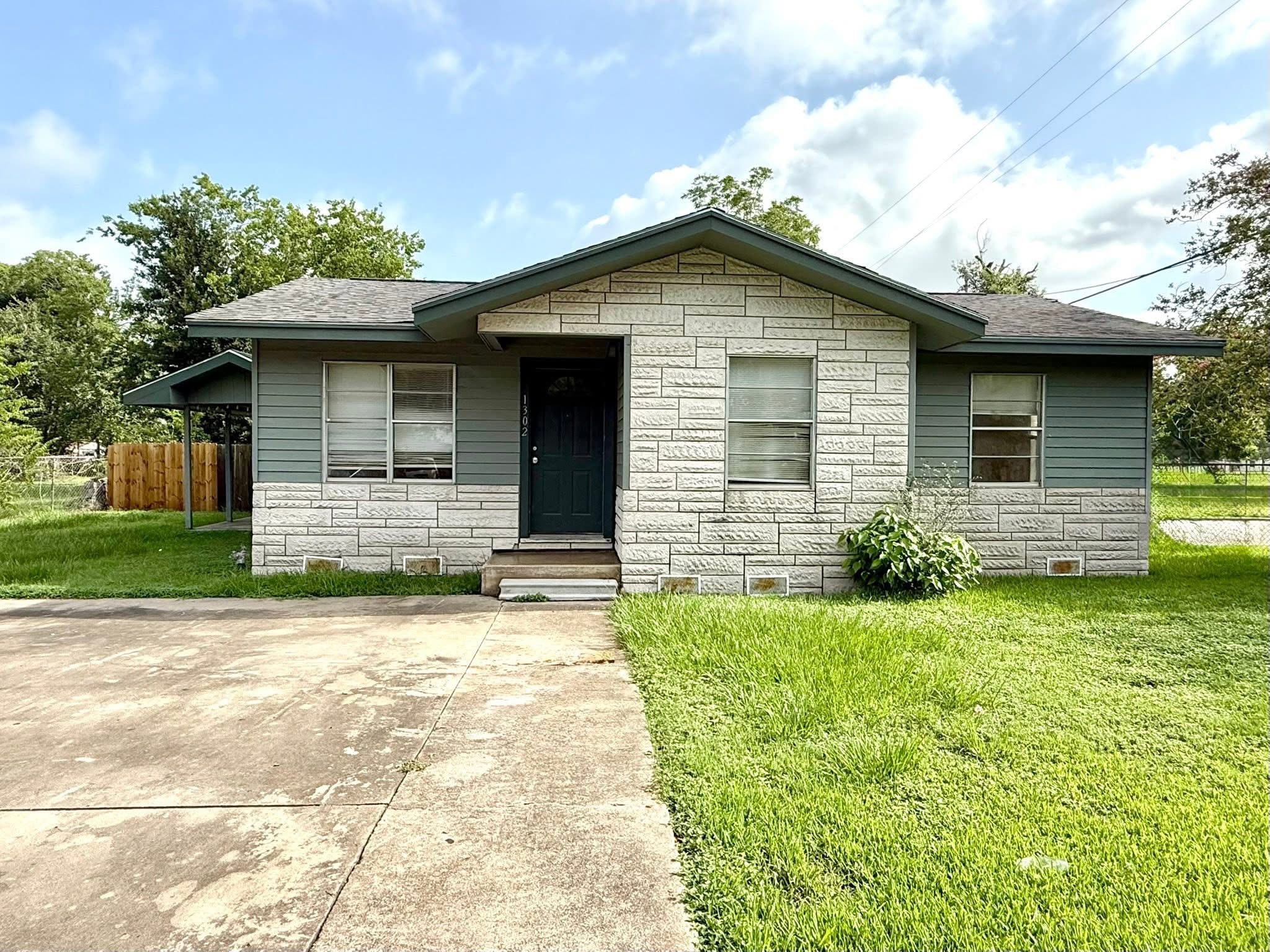 A house with a grey roof and a green lawn.