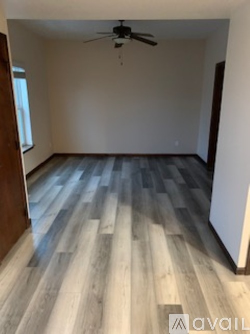 A room with a wooden floor and a ceiling fan.
