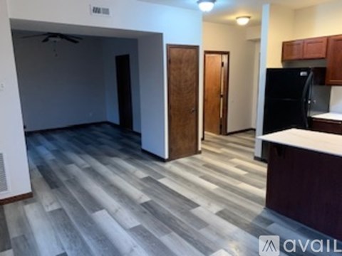 A kitchen with a refrigerator and cabinets is visible.