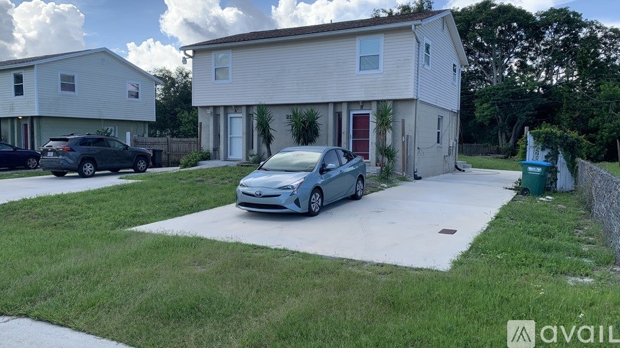 A blue car is parked in front of a house.