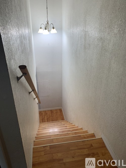 A staircase with wooden steps and a light hanging from the ceiling.