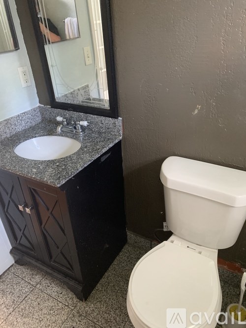 A white toilet sits next to a sink in a bathroom.