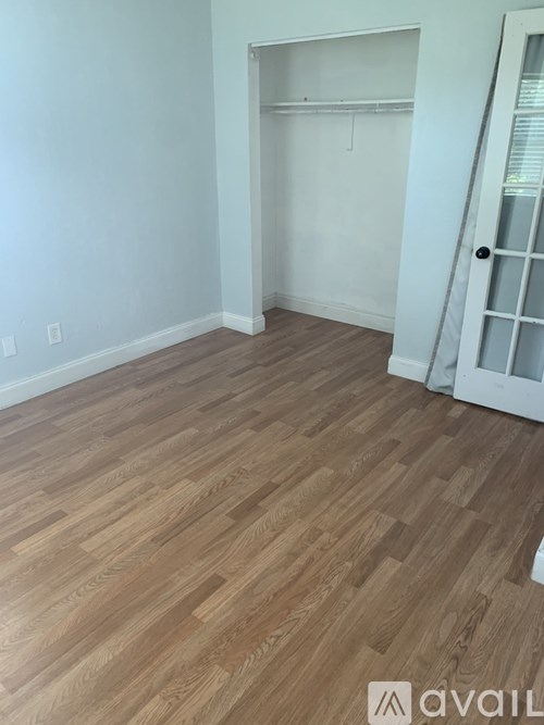 A room with wooden flooring and white walls.