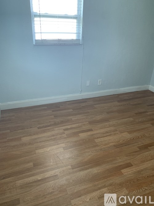 A room with wooden flooring and a window.