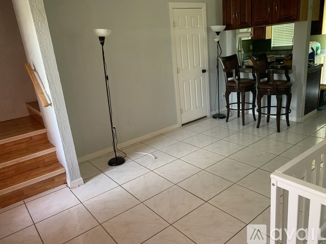 A white tiled floor with a black microphone stand in the middle.