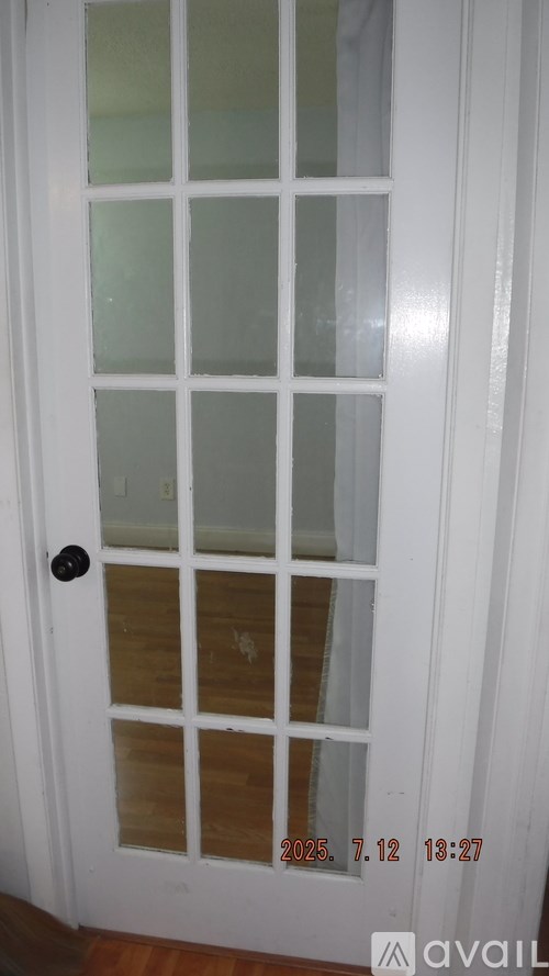 A white door with a black handle and a window with a white frame.