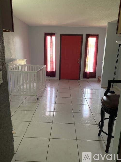 A baby's room with a white crib and a red door.