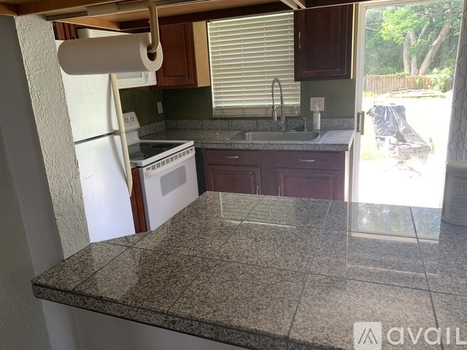 A kitchen with granite countertops and a white refrigerator.