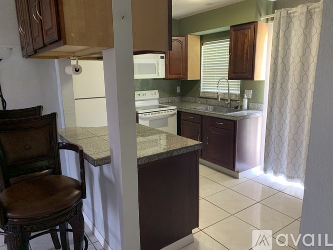 A kitchen with brown cabinets and a white fridge.