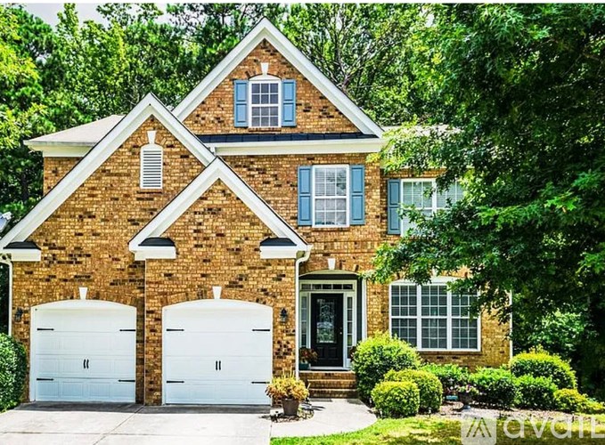 A brick house with a white garage door and a black door.
