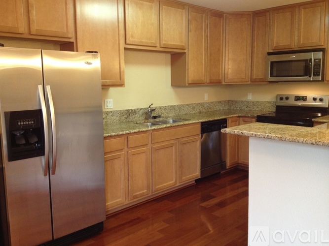 A kitchen with wooden cabinets and a stainless steel refrigerator.