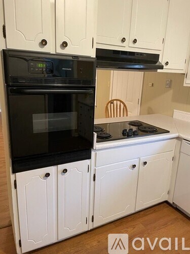 A kitchen with white cabinets and a black oven.