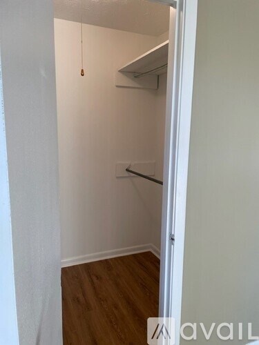 A white door is open to a room with a wooden floor.