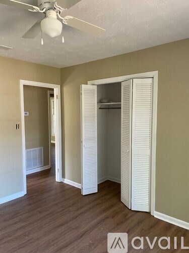 A room with a fan and a wardrobe.
