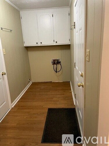 A hallway with white doors and a black doormat.