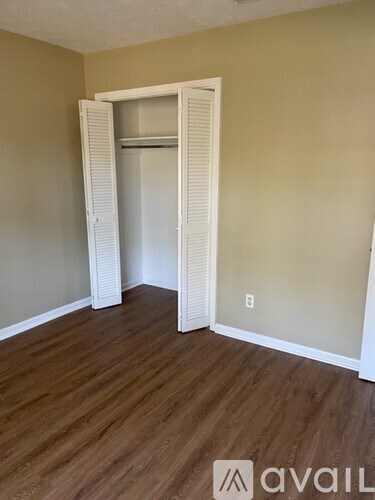 A room with a white closet and wooden floors.